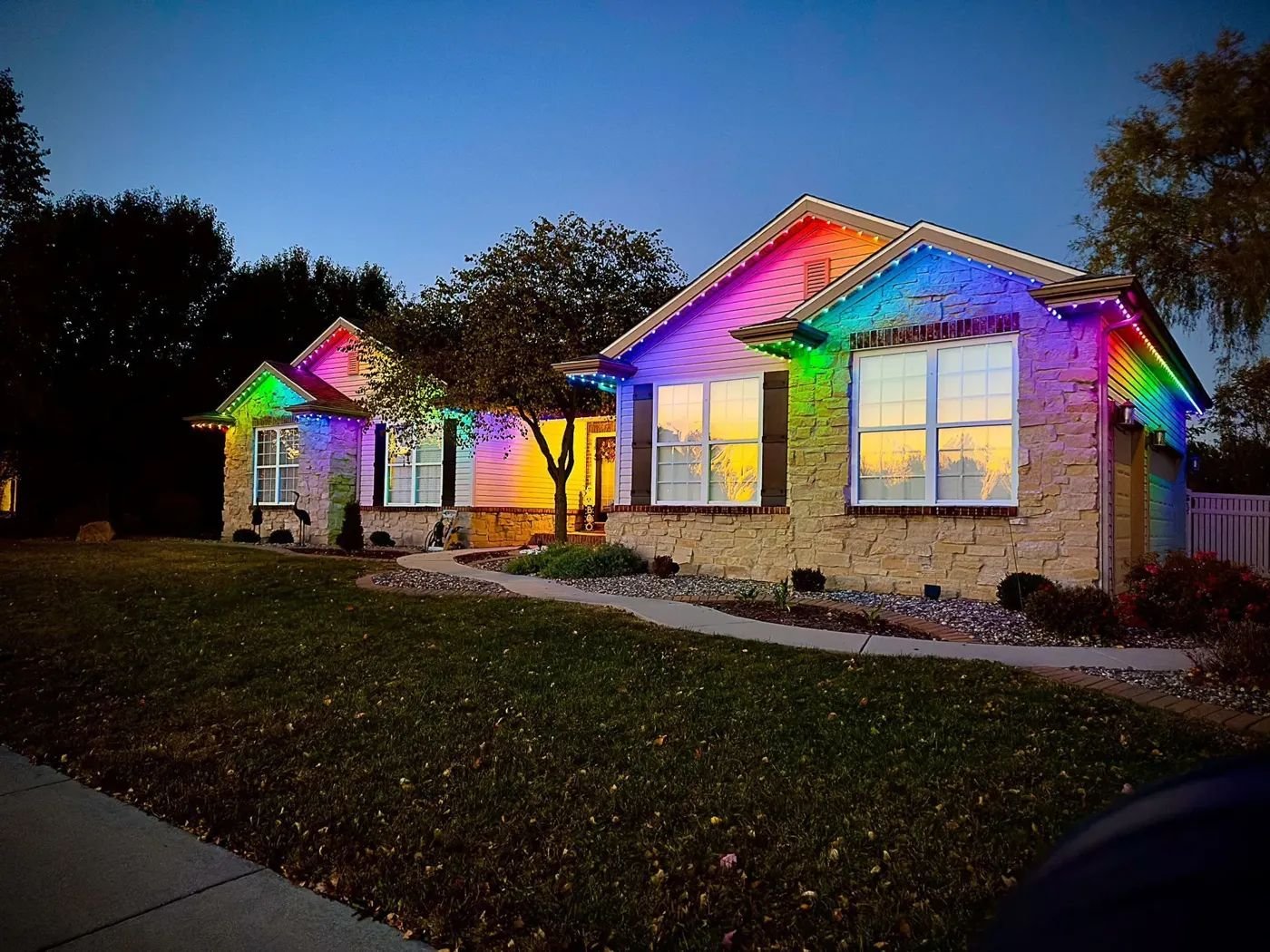 Ranch home glowing with rainbow permanent roofline lights